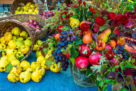 Autumn bouquet and quinces in basket on blue fabric