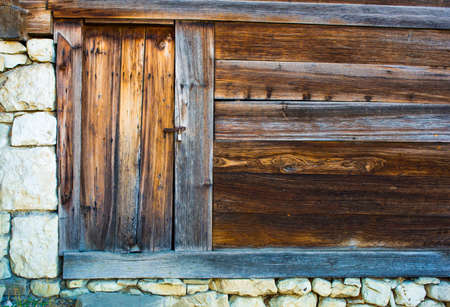 Old door on stone and wood wallの写真素材