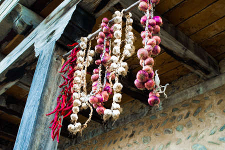 Hanging bunch bundle of onion, chili and garlicの写真素材