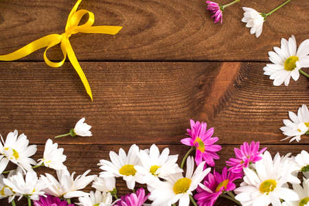 Chrysanths and yellow ribbon on wooden backgroundの写真素材
