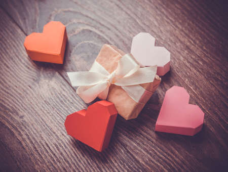 Bright paper hearts and gift box on wooden backgroundの写真素材