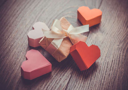 Bright paper hearts and gift box on wooden backgroundの写真素材