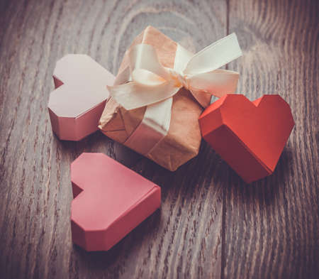 Bright paper hearts and gift box on wooden backgroundの写真素材