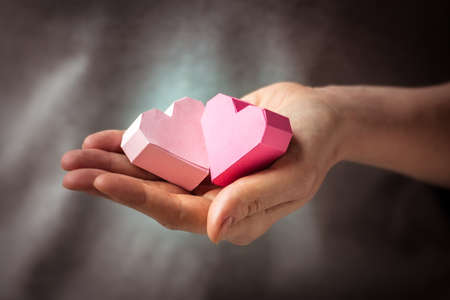 Bright paper hearts in woman handsの写真素材