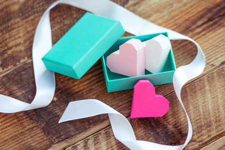 Bright paper hearts in gift box on wooden backgroundの写真素材