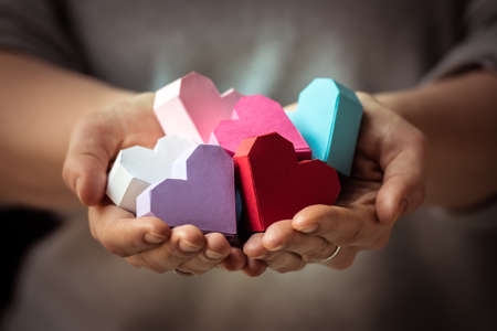 Bright paper hearts in woman handsの写真素材