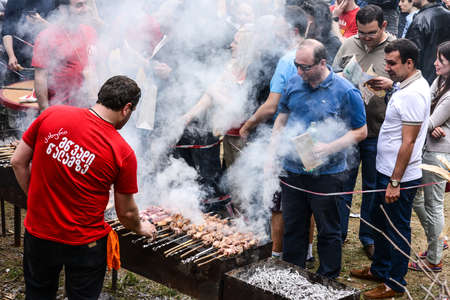 TBILISI - MAY 15, 2013 - Unidentified man prepares barbecue on the grill at the annual Young Wine Festival in Tbilisi, Georgia.のeditorial素材