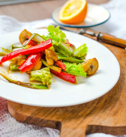 Bell pepper, avocado, mushrooms and leek salad on white plateの写真素材
