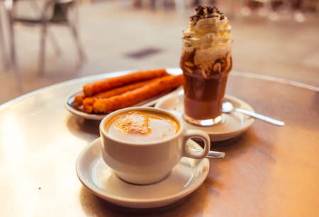 Coffee, churros and iced chocolate in spanish cafe. Toned in vintage colorsの写真素材