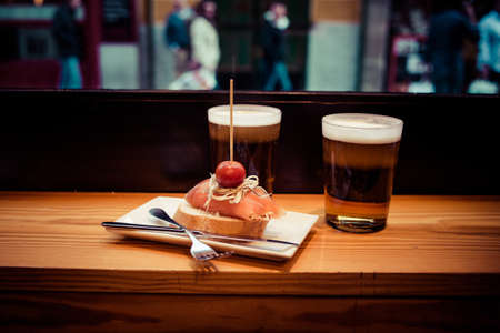 Pinchos or pintxos, traditional Basque Country appetizer. Served with beerの写真素材