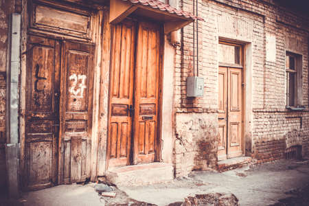 Three wooden doors with ornament and brick wall in Old Tbilisi, Georgia. Toned in vintage colorsの写真素材