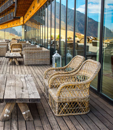 Rattan chairs and table on terrace in mountainsの写真素材