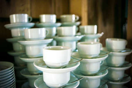 Stacking white porcelain cups for tea and coffee with platesの写真素材