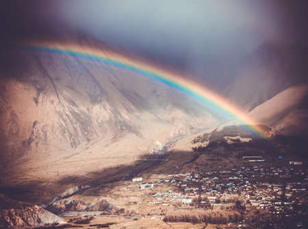 Bright rainbow after rain in Caucasus mountains near Kazbek (Kazbegi), Georgia. Picture toned in retro styleの写真素材