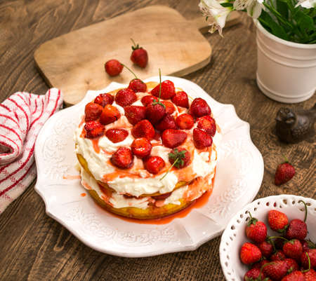 Strawberry cake with whipped cream in wooden tableの写真素材