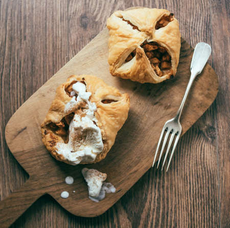 Delicious homemade apple strudel with ice cream on wooden background. Toned pictureの写真素材