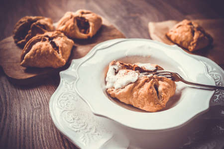 Delicious homemade apple strudel with ice cream on wooden background. Toned pictureの写真素材