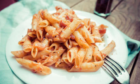 Penne pasta with tomato sauce arrabiata and cheese parmesan. Toned pictureの写真素材
