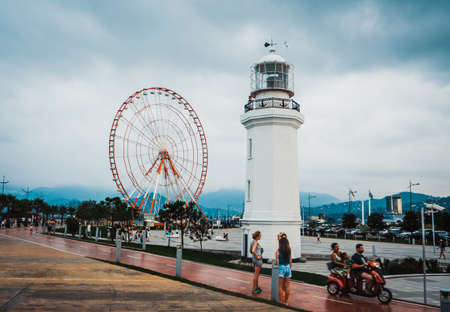 BATUMI, GEORGIA - CIRCA AUGUST 2014: Ferris wheel and old lighthouse in Batumi circa August 2014. There is a lot of modern construction for tourism development in recent years in Batumiのeditorial素材