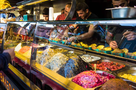 ISTANBUL, TURKEY -  october 23, 2014  Vendors sell traditional turkish street food kumpir in street market at Ortakoy square in Istanbul, Turkey.のeditorial素材