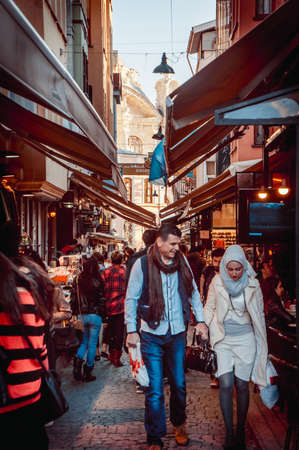 ISTANBUL, TURKEY -  october 23, 2014: A couple walks along the street market in Ortakoy aquare in Istanbul, Turkey. Toned image.のeditorial素材