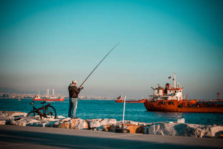 ISTANBUL, TURKEY, October, 26, 2014: Man is fishing on Marmara sea quay in Bakirkoy in Istanbul, Turkey.のeditorial素材