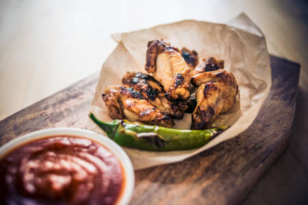 Fried buffalo chicken wings on wooden board. Toned imageの写真素材