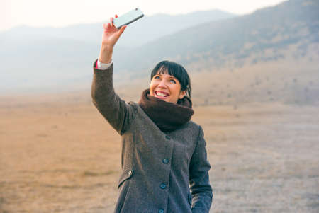 Pretty girl makes selfie with her smart phoneの写真素材