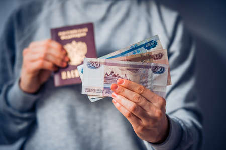 Russian passport and russian rouble bills in handの写真素材