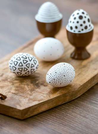 Modern painted easter eggs on wooden board