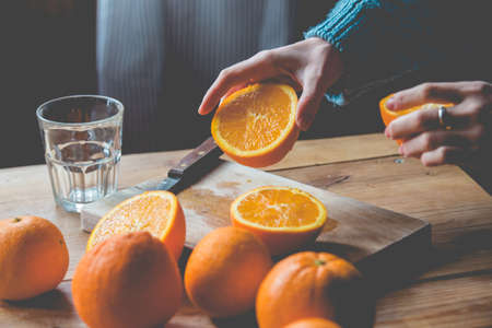 Fresh oranges on wooden table. Toned pictureの写真素材