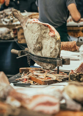 Italian dry-cured ham prosciutto in butchers shop. Toned imageの写真素材