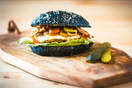 Modern black burger on wooden boardの写真素材