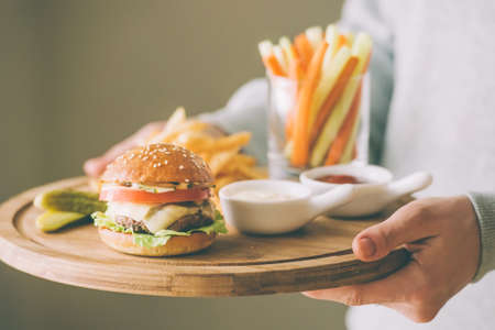 Lunch menu with small burger, french fries and vegetable sticks. Toned pictureの写真素材