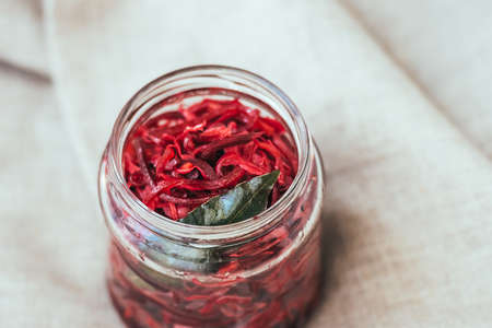 Pickled cabbage with beetroot and bay leaf in a small jarの写真素材
