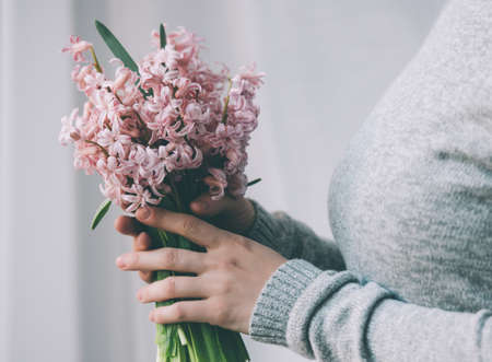 Young woman holding hyacinth flowers bouquet. Toned imageの写真素材