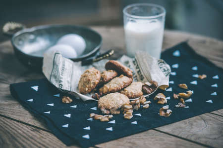 Homemade oat and nut cookies and glass of molk on wooden table. Toned pictureの写真素材