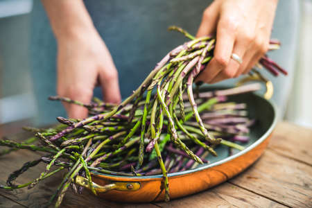 Hands holding a bunch of fresh asparagus. Selected focus and shallow DOFの写真素材
