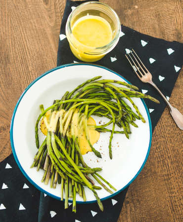 Boiled green asparagus dressed in mustard vinegar and olive oil dressing mayonnaise or hollandaise sauceの写真素材
