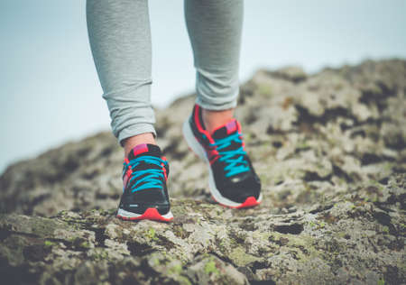 Walking or running legs on trail, adventure and exercising concept. Toned imageの写真素材