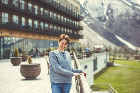Young woman posing near beautiful hotel in mountains. Tourism and leisure conceptの写真素材