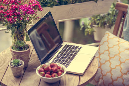 Beautiful terrace or balcony with small table, chair and flowers. Selective focus and shallow DOF. Toned imageの写真素材