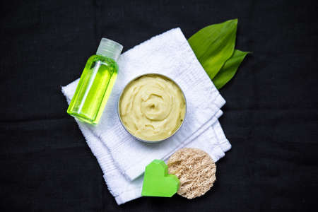 Different cosmetic bottle containers and accessories for facial care from top on dark backgroundの写真素材