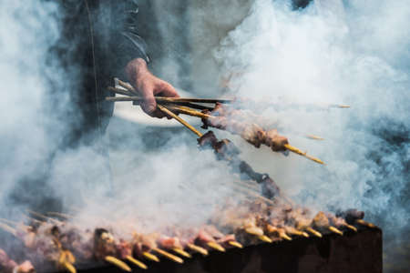 Preparation of barbecue on grill. Roasted meat slices shashlik. Selective focus and shallow DOFの写真素材