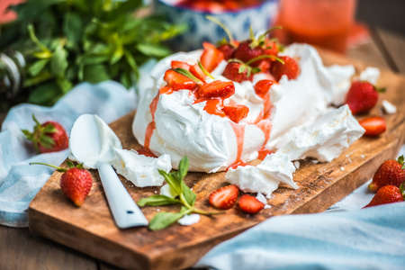 Classic british summer dessert called Eton Mess. Strawberries, crushed meringue and whipped cream on wooden boardの写真素材