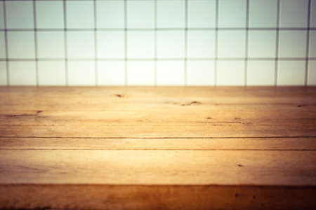 Empty kitchen wooden table and white tile background. Perfect for product montage. Selective focusの写真素材