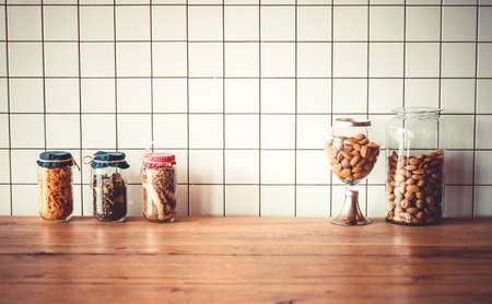 Jars with different grocery items on wooden kitchen table. Toned imageの写真素材