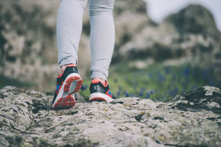 Walking or running legs on trail, adventure and exercising concept. Toned image