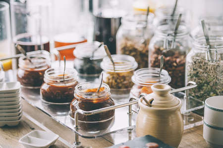 Glass jars with homemade jam, nuts and cereals. Toned imageの写真素材