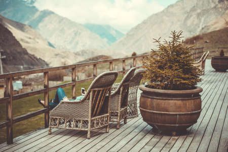 Girl sitting on terrace with beautiful mountain view. Toned imageの写真素材